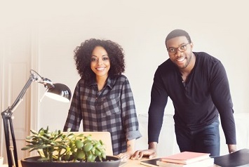 Man and woman leaning on a neat desk, using IONOS Mail