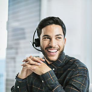 Mann mit Headset, der zur Seite schaut und lächelt