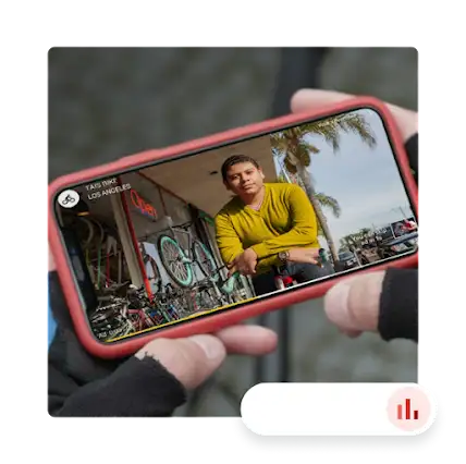 Ruke drže mobilni telefon na kojem se reproducira videozapis