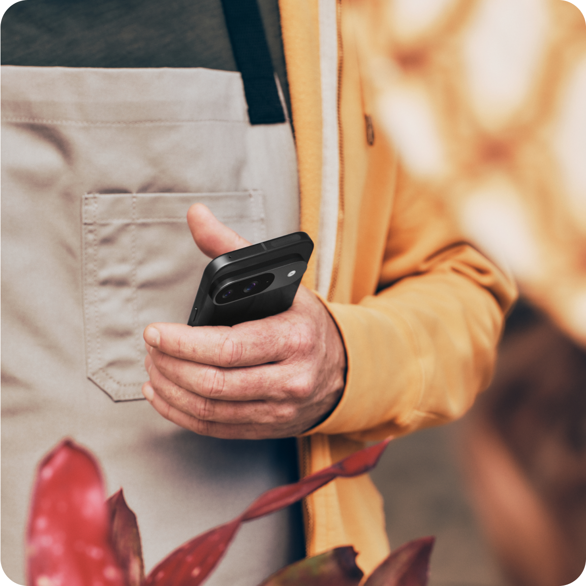 A man using his Google Pixel 9 phone at his flower shop.