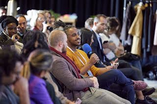 A guy speaking something on mic among the group of people