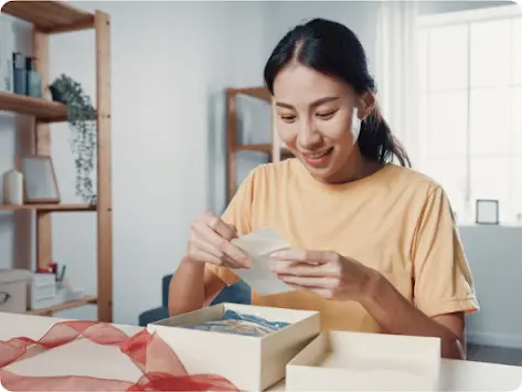 Femme qui ouvre un cadeau et lit une carte