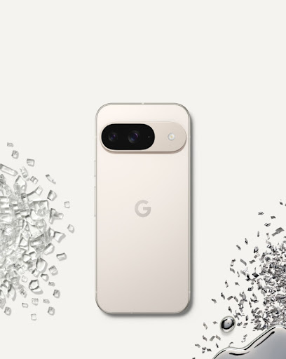 Back of Pixel 9 in Porcelain color against a porcelain-colored background, surrounded by glass and metal shards.