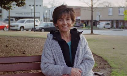 A woman sitting on a bench who has shared details about her relationship to technology.