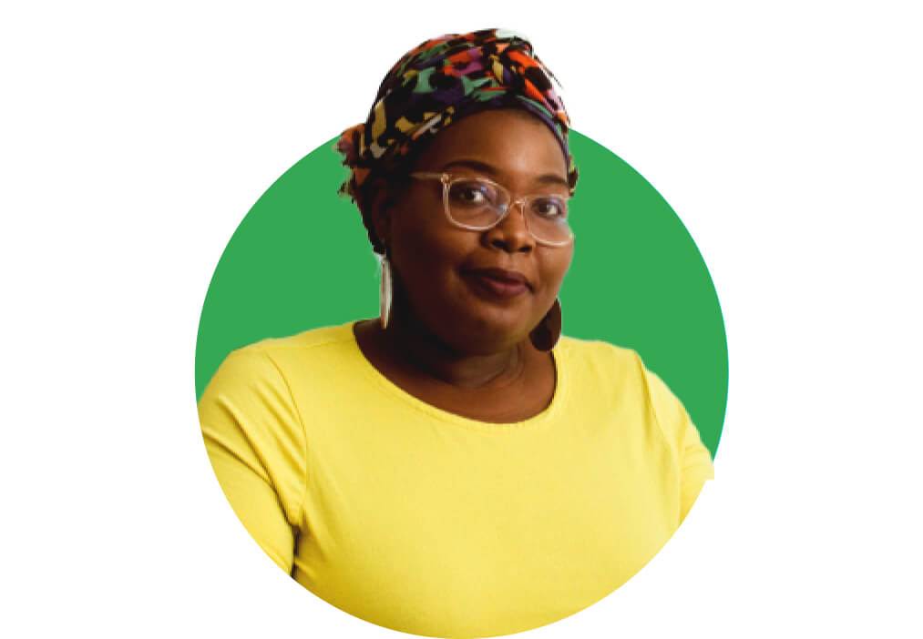 An education leader smiles in front of a plain green background.