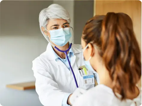 A doctor checks the heartbeat of a patient.