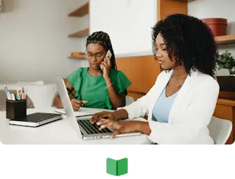 Une femme prend des notes alors qu’elle est au téléphone, et une autre travaille sur son ordinateur portable.