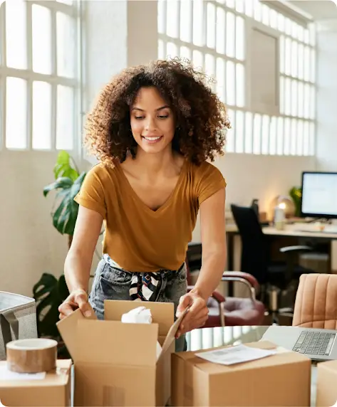 Una donna è intenta a preparare una scatola di cartone per la spedizione