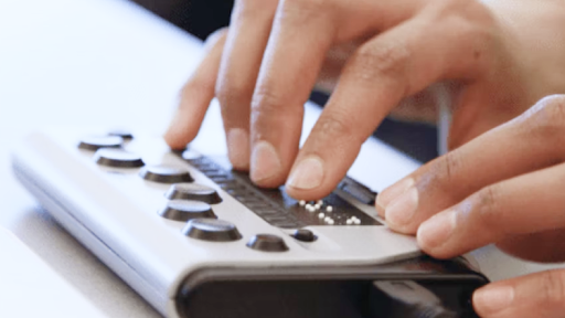 Hands hovering over a braille reader