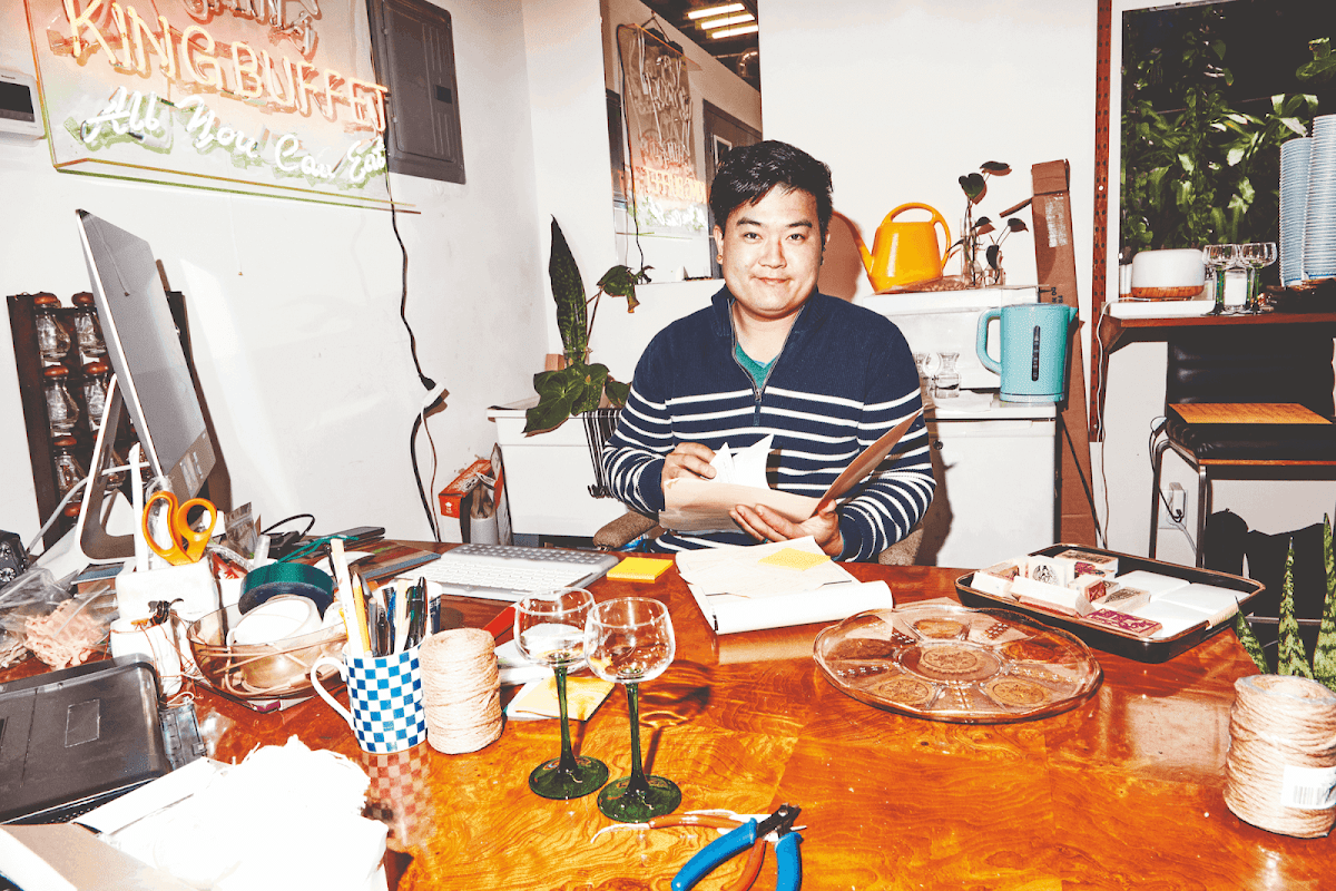 Man sitting at a desk, sorting through various papers