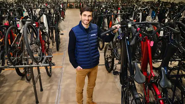 Upway Founder standing in a warehouse with bicycles.