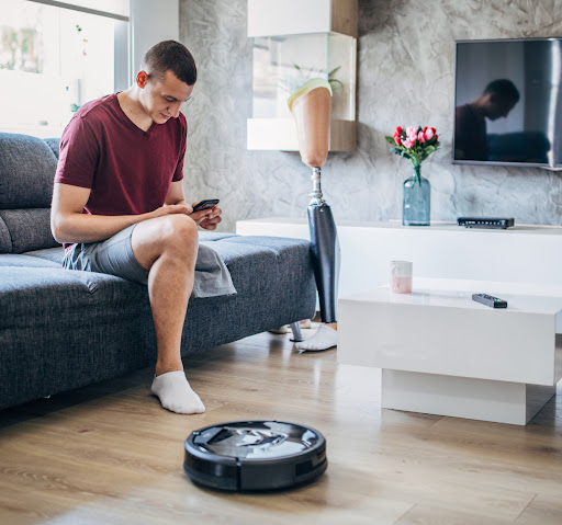 A man in a living room controlling a vacuum with his Google Home app