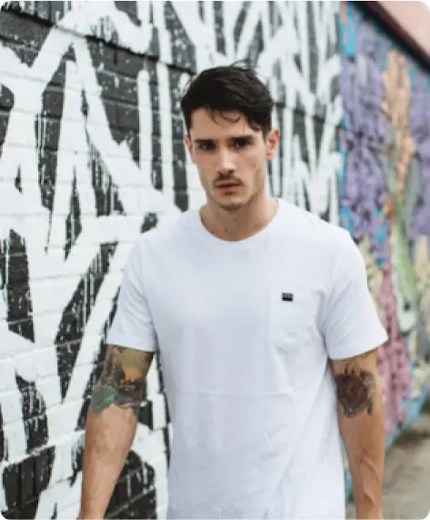 Modelo masculino da Diesel.ie caminhando em frente a um muro com grafite.