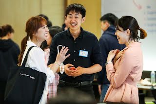 Two women and a men discussing something and laughing.