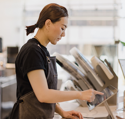 De medewerker van een koffiezaak tikt op een tablet.