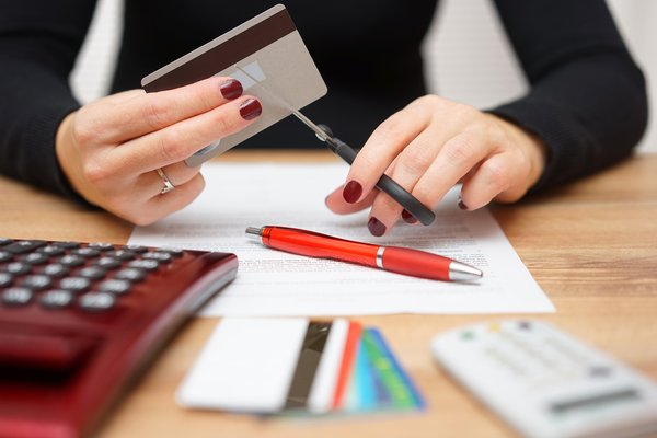 A person cuts a credit card with scissors.