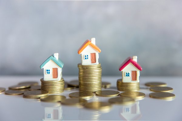 Miniature houses on top of stacks of coins.