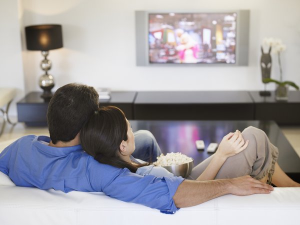 Couple watching tv together from the couch.