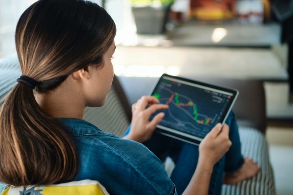 Person using a tablet to look at the performance of stocks.