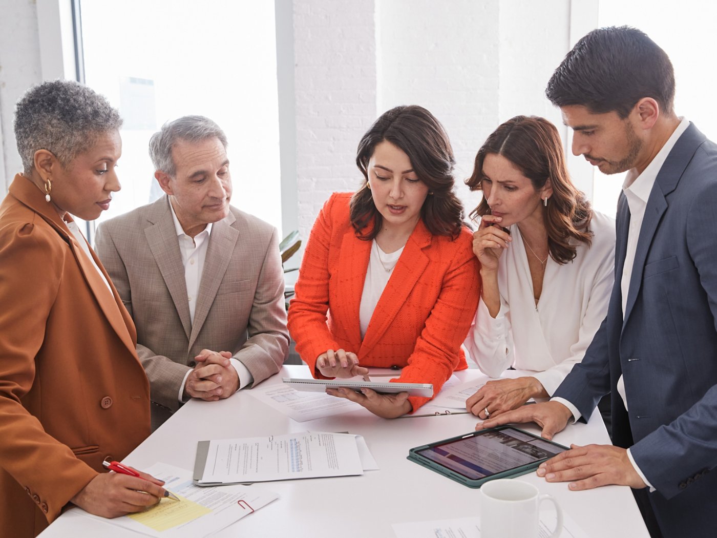 five multi ethnic business people discussing a business report