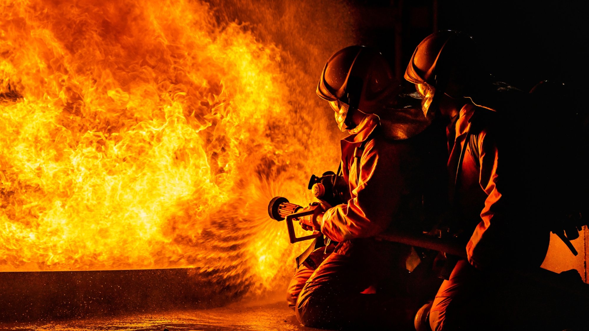 Panoramic firefighters using Twirl water fog type fire extinguisher to fighting with the fire flame from oil to control fire not to spreading out. Firefighter and industrial safety concept.