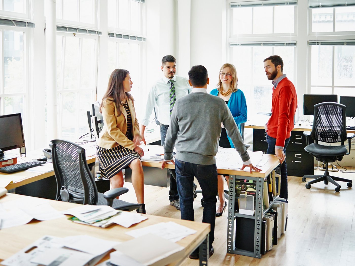 Group of coworkers discussing project at table in office