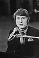 Black-and-white photograph of Udo Jürgens performing at a piano with mic stand.