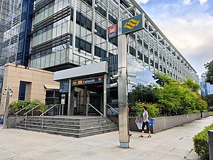 Photograph of Exit C at street level in front of a building. A sign over the entrance indicates the station's name and alphanumeric code (NE3).