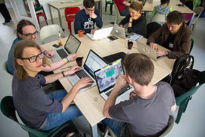 A group of people working on laptop computers at a common table