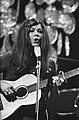 Black-and-white photograph of Lenny Kuhr performing on stage in 1969 with guitar and mic stand.