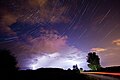 The constellation of Cassiopeia over a thunderstorm.