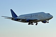 Side quarter view of four-engine jet climbing in the sky.