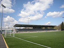 A modest stadium's grandstand over a soccer field