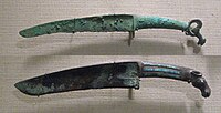 Shang dynasty curved bronze knives with turquoise inlays and animal pommel. 12th-11th century BC. Such knives may be the result of contacts with northern people.[92][93]