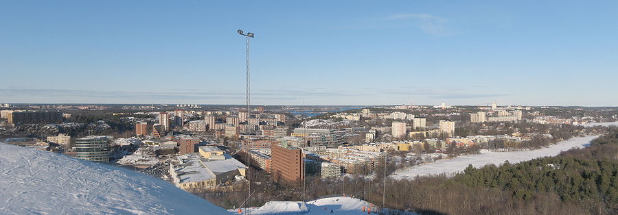 Översiktsbild av västra Nacka från Hammarbytoppen. Längst till vänster ligger Henriksdalsberget, i bakgrunden finns Lidingö med bland annat Larsberg och Bodal, i vattnet mellan Lidingö och Nacka ligger Fjäderholmarna. Till vänster om masten finns Alphyddan tegelklädda höghus. I förgrunden är Sickla och Sicklasjön. Bakom ligger Järlasjön med bostadsområdena Ekudden, Nacka och Järla sjö. I förgrunden till höger finns Nackareservatets skogar. I bakgrunden till höger sticker höghuset vid Nacka forum upp.