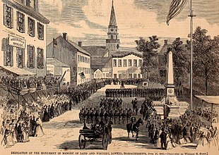 A black and white lithograph of a city square, a stone obelisk and large formations of militia soldiers in dark uniforms parading past the monument