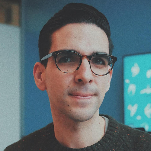 Photograph of a white man with short brown hair and round glasses.