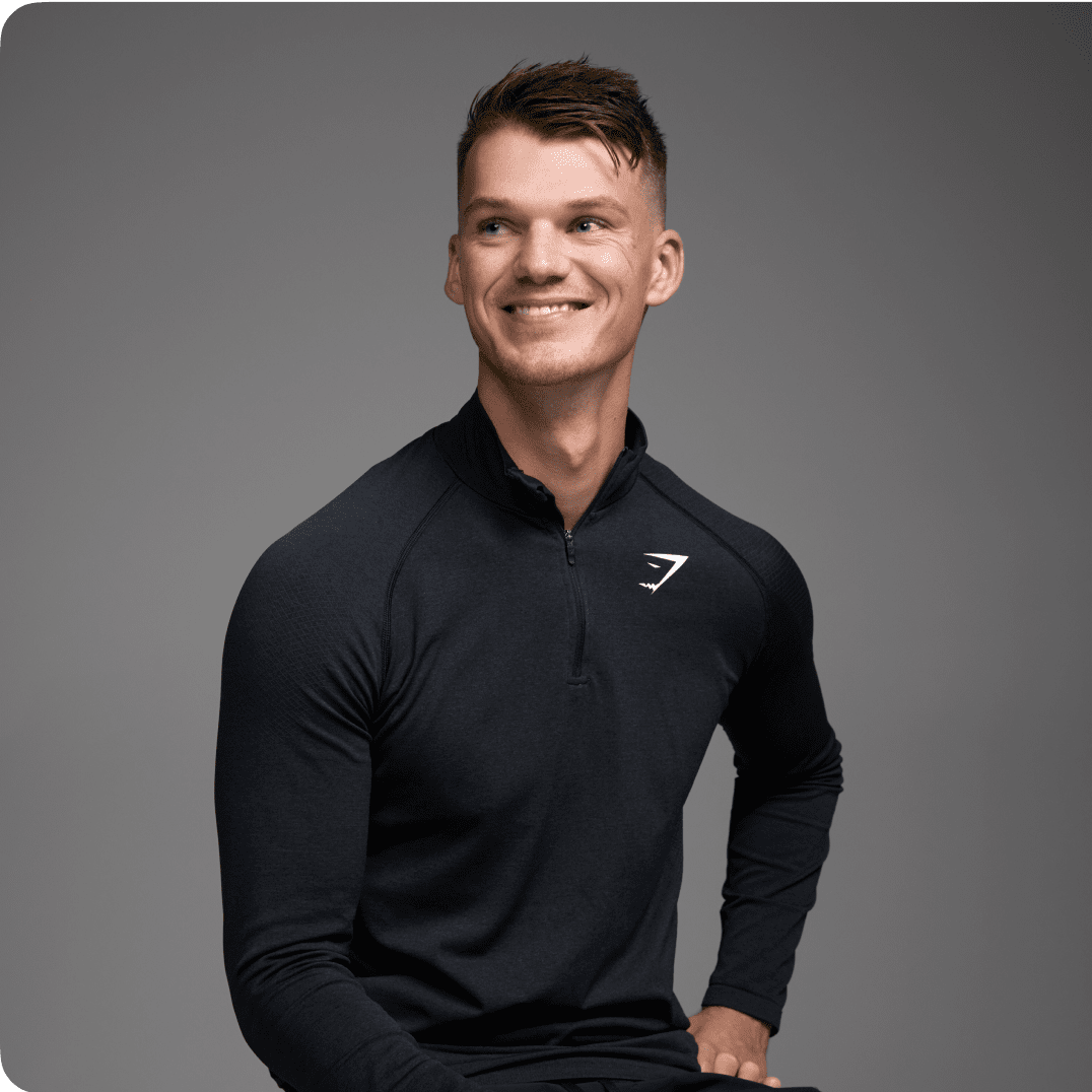 A man smiles broadly while  wearing a long-sleeved Gymshark-branded shirt; before him, a graphic reads, "Nine percent reduction in user drop-offs."