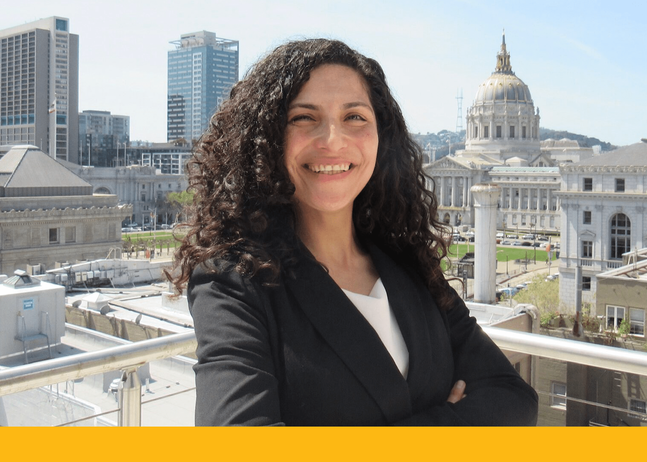 student smiling at the camera with a view of san francisco city hall in the backdrop