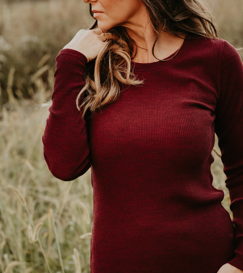 Woman wearing cranberry melange hadley ribbed crew top in field