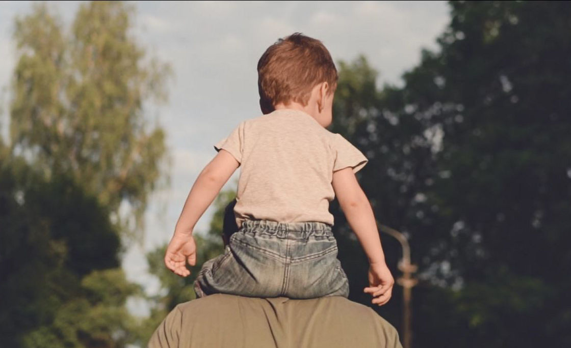 child on father shoulders