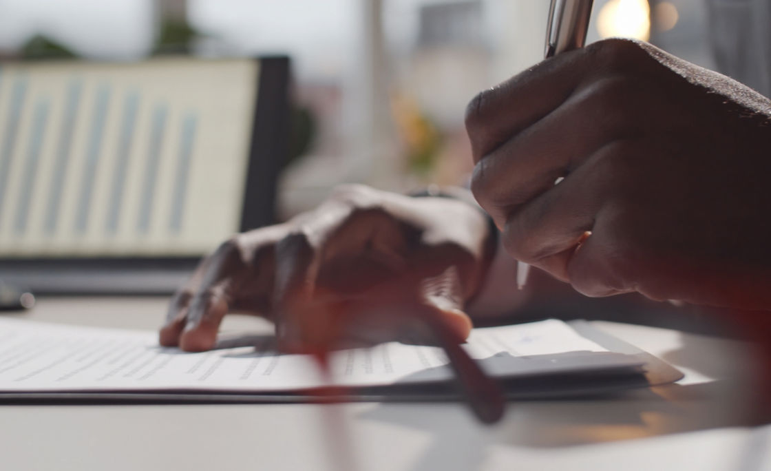 Man holding pen in hand and writing something 