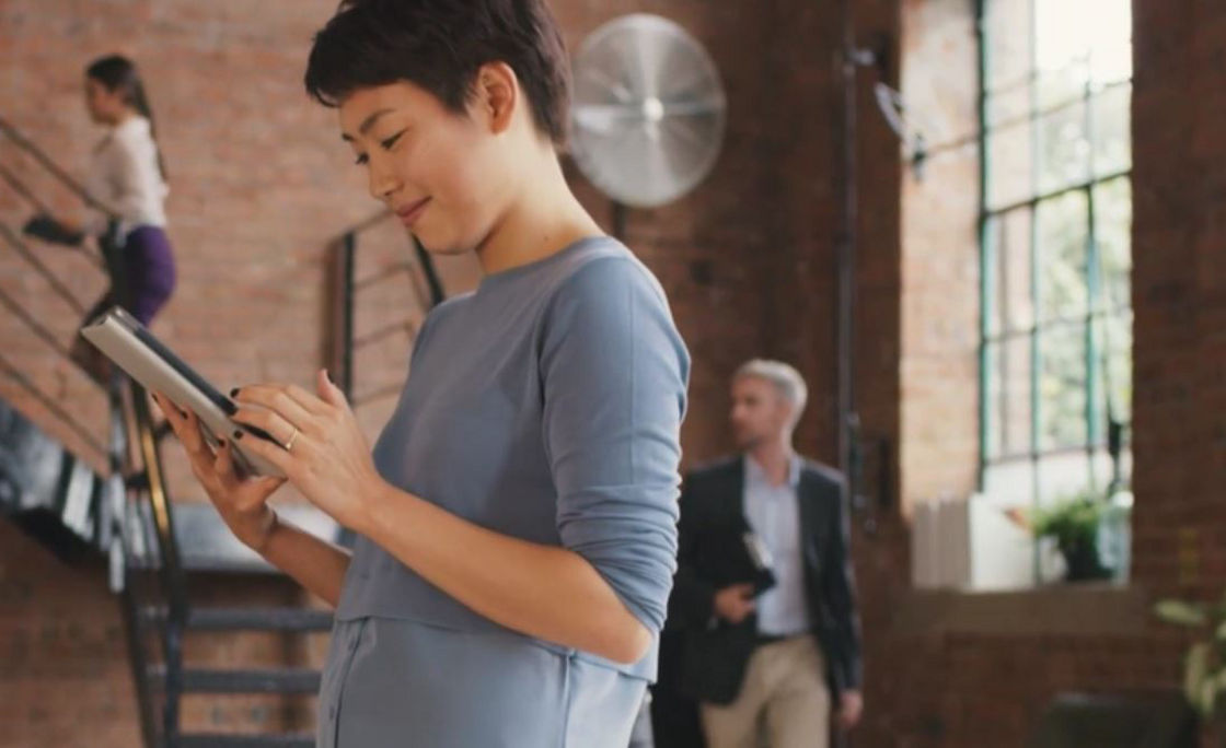 Person working on a tablet and smiling