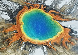 Grand Prismatic Spring (in het nationaal park Yellowstone) met het azuurblauwe water en daaromheen lagen van feloranje algen, bacteri�n en archaea.