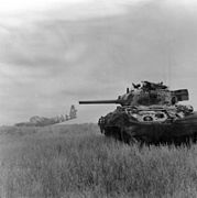 Ein britischer Sherman-Panzer der 13./18. königlichen Husaren im Einsatz gegen deutsche Infanterie (Normandie, 10. Juni 1944)