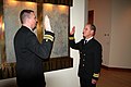 Un lieutenant commander médecin de bord faisant prêter serment à un autre lieutenant commander médecin.