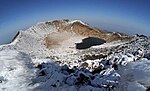 View into an inactive volcanic crater with a small like.