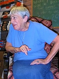 Le Guin sentada numa livraria