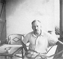 Photographie d'un homme assis à une table.