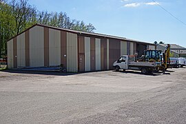 Bâtiment en tôle et véhicules de chantiers.